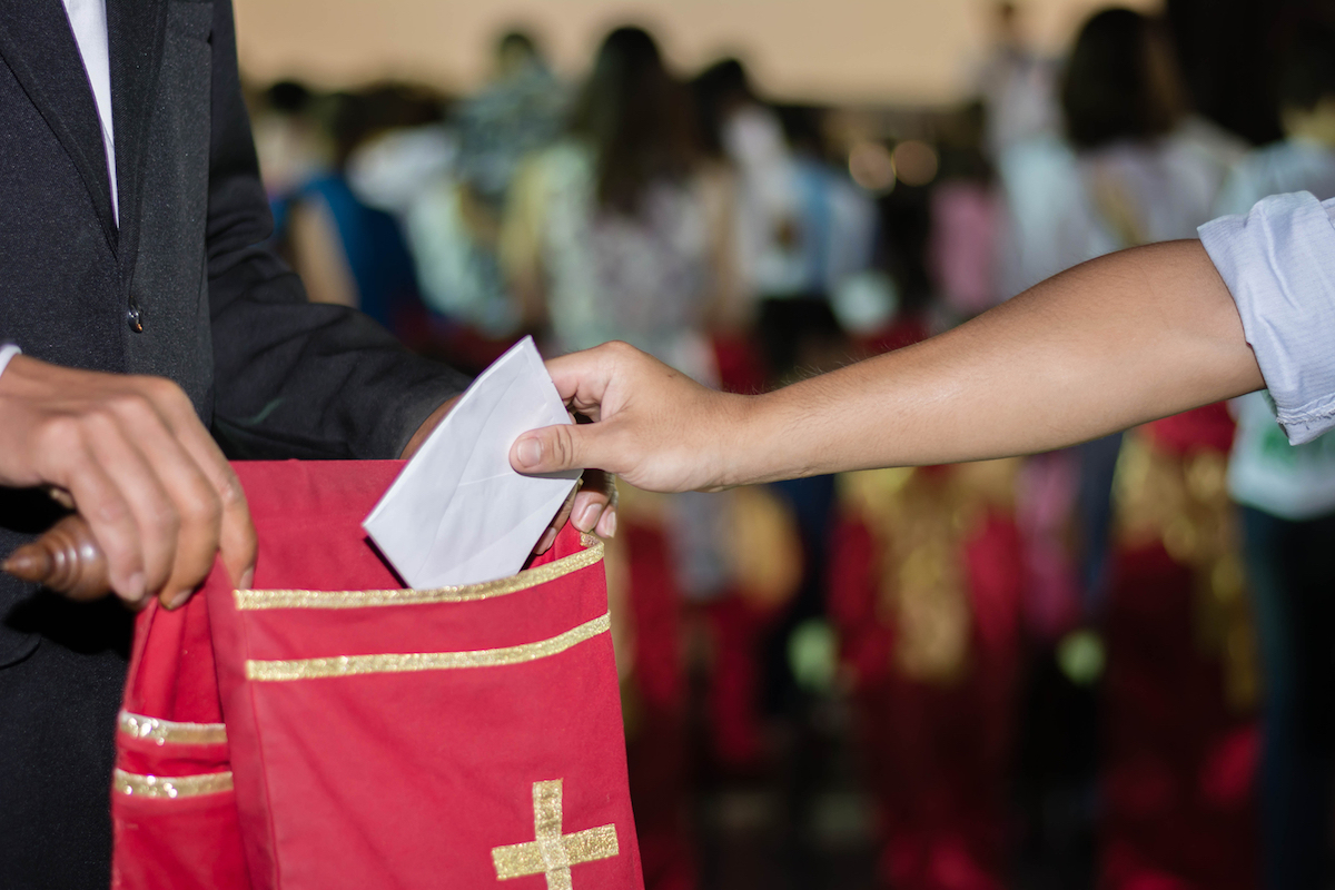 people putting tithing into Velvet offering bag in church